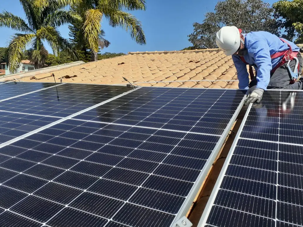 Técnico da WJ Energia fixando módulos solares em telhado
